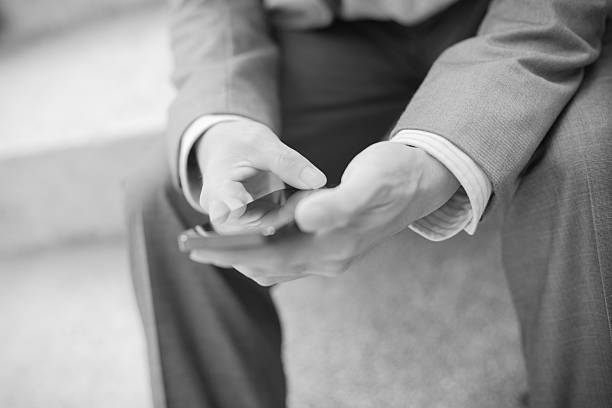 istock Young businessman using a phone sitting on the stairs 475318966