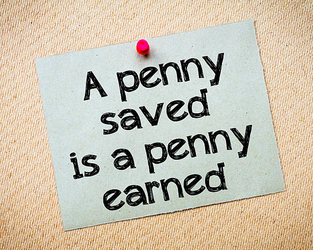 Penny saved is one earned A penny saved is a penny earned Message. Recycled paper note pinned on cork board. Concept Image a penny saved stock pictures, royalty-free photos & images