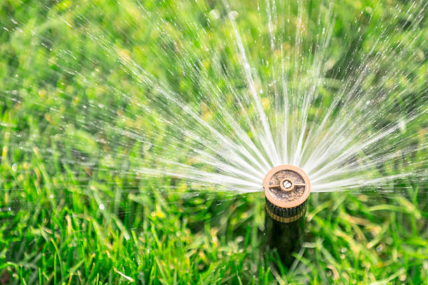 Automatic sprinkler automatic sprinkler watering fresh lawn agricultural sprinkler stock pictures, royalty-free photos & images