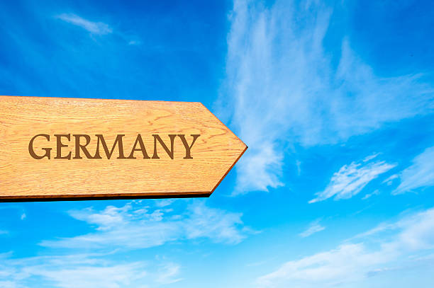 Wooden arrow sign pointing destination GERMANY against clear blue sky with copy space available. Travel destination conceptual image