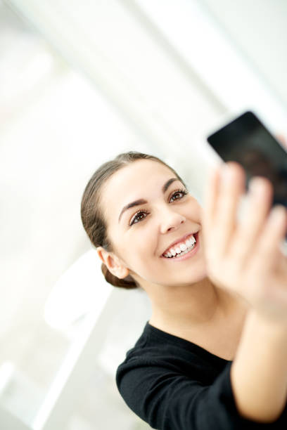 istock Happy woman taking a selfie on her mobile 475326410