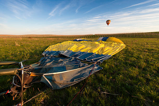 Inflating a blue hot air balloon on the grass