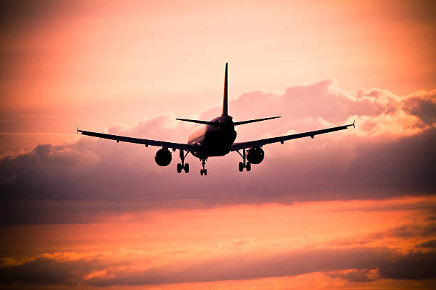 istock Airplane landing at sunset 475332307