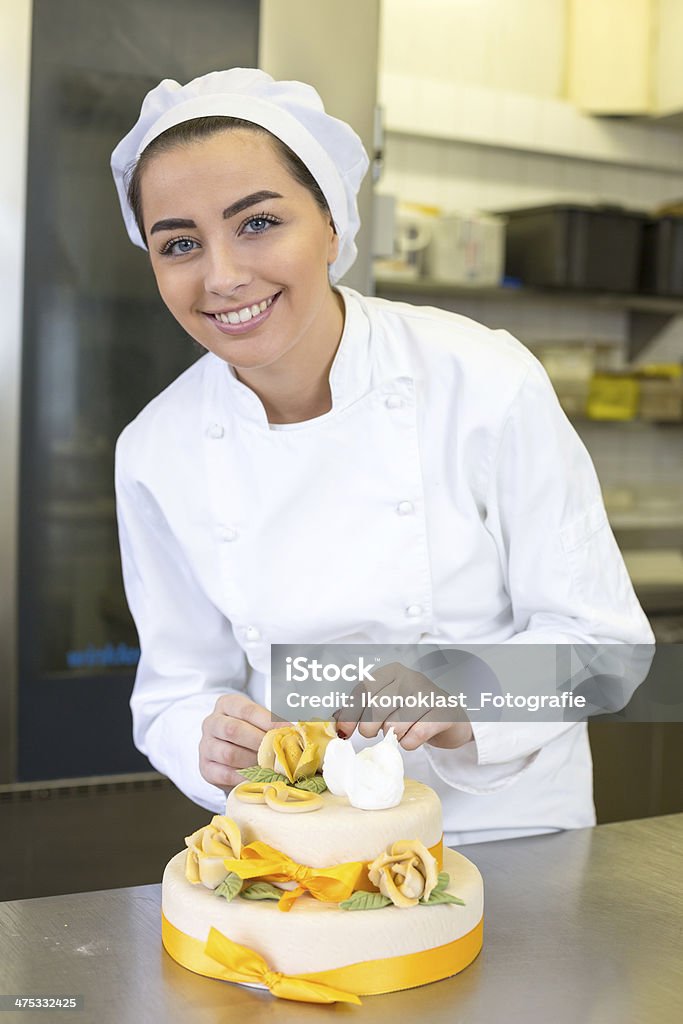 confectioner, baker or pastry cook preparing cake confectioner, baker or pastry cook preparing cake in bakery Confectioner Stock Photo