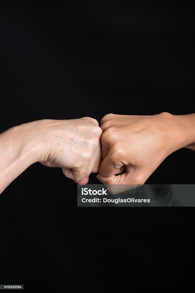 Fist-bump over Black Background Fist-bump captured over black background for isolation. Fist Bump Stock Photo