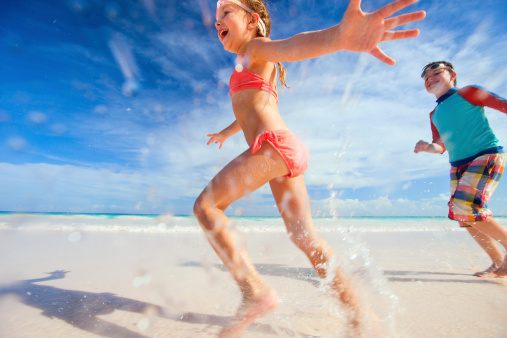 Happy kids running and jumping at beach