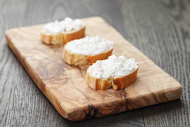istock crunchy baguette slices with cream cheese on olive board 475336636