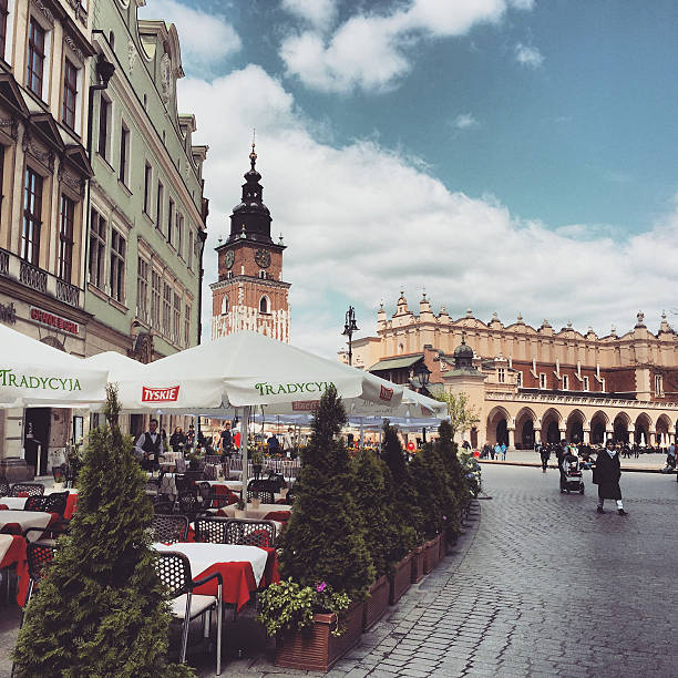 Krakow, Poland - April 29, 2015: Krakow city center with cafe and numerous tourists sightseeing. 