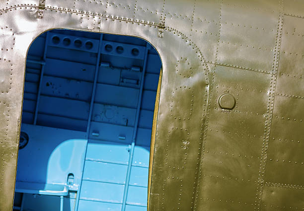 Fragment of old military green aircraft with open doorways close-up.