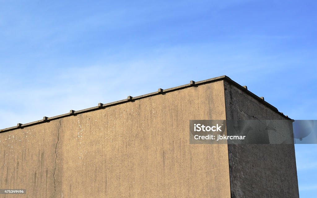 Detail of boring house against blue sky A blank wall of a boring industrial-style building against the blue sky 2015 Stock Photo