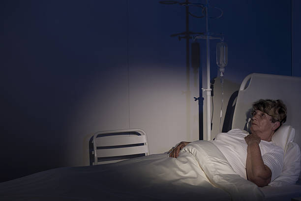 Terminally ill woman Terminally ill woman on a palliative care unit night hospital bed stock pictures, royalty-free photos & images