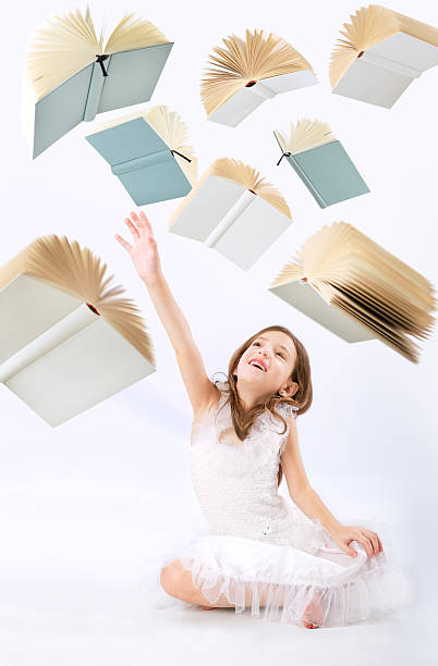istock Flying books over little girl looking up 475361911