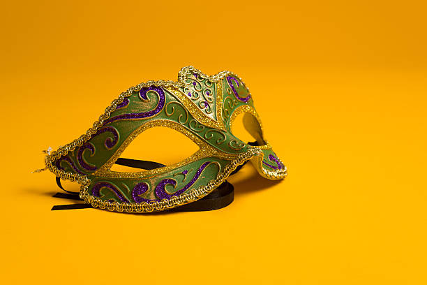 Green and gold Mardi Gras, venetian mask on Yellow background Green, gold, purple mardi gras mask on a bright yellow background purple and gold masquerade masks stock pictures, royalty-free photos & images