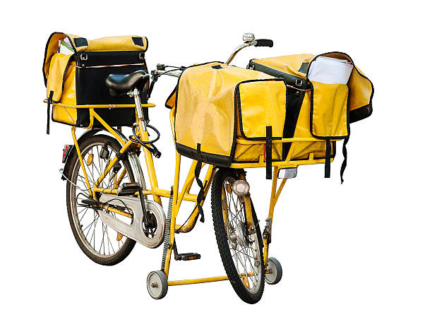 A yellow bicycle with three bags used for delivering post in the city, spotted on the streets of Berlin, isolated, on white background, with paths