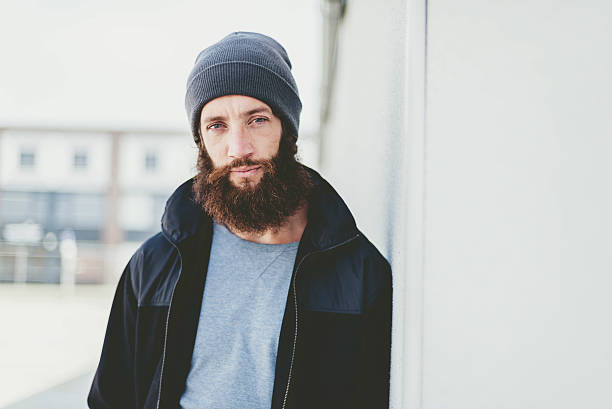 istock Young Man in Jacket and Bonnet Leaning on Wall 475372866