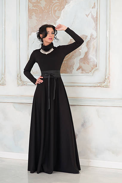 istock Woman in elegant long black dress in studio 475373200