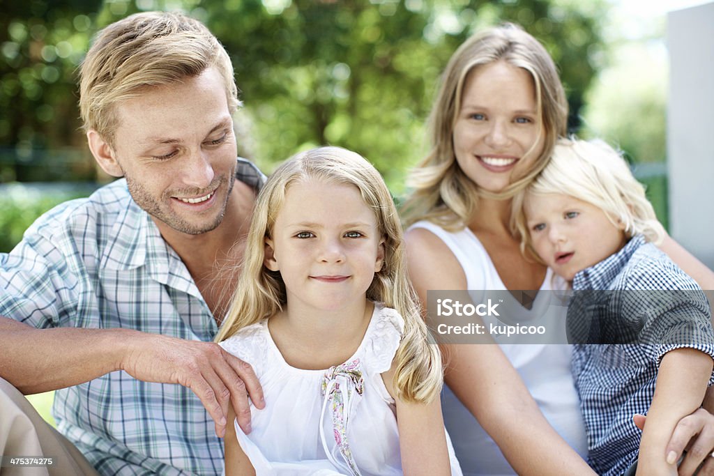 He's so proud of his little family! A happy family of four smiling while outside in a garden - Portrait 30-39 Years Stock Photo