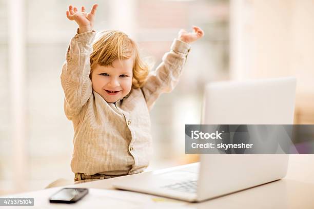 Cheerful Business Boy Celebrating In Office With His Arms Raised Stock Photo - Download Image Now