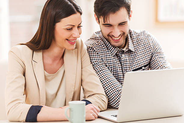 istock Smiling business colleagues using laptop together. 475375120