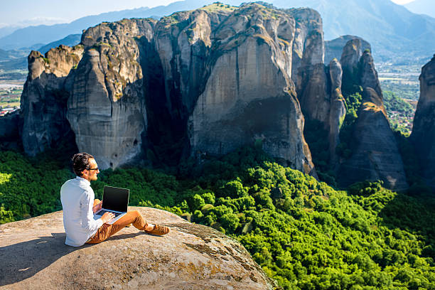 hombre con ordenador portátil en la montañas - on top of business cliff businessman fotografías e imágenes de stock