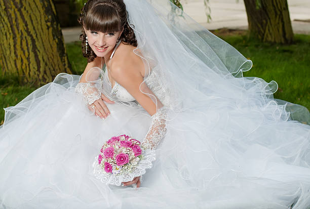 istock Young beautiful bride in wedding dress with a bouquet 475384361