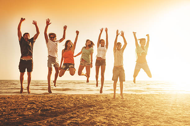 istock group of friends jumping on the beach 475386185