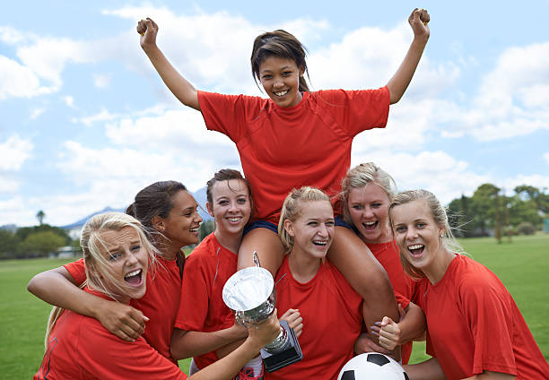 We are the champions! Portrait of an all-girls soccer team raising their captain in triumph team sport photos stock pictures, royalty-free photos & images