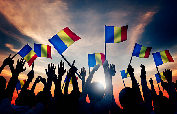 istock Group of People Waving Romanian Flags in Back Lit 475386796