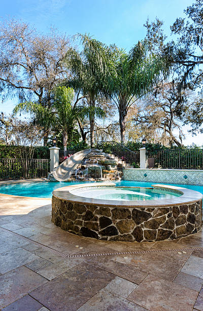 istock Spa and swimming pool with slide plus waterfall 475389725