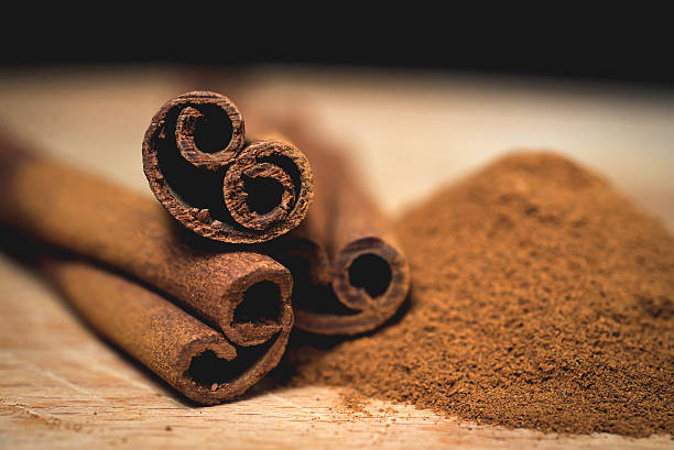 istock Cinnamon sticks with cinnamon powder on wooden background, Selective focus 475394784