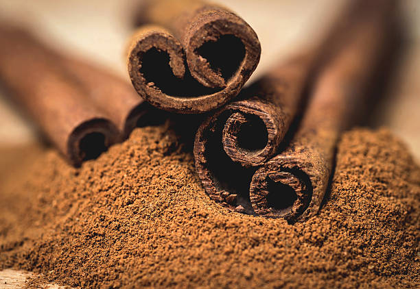istock Cinnamon sticks with cinnamon powder on wooden background, Selective focus 475394798