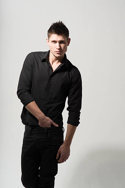 istock Man in black shirt on grey background in studio 475394944