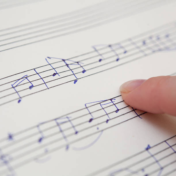 istock Hand with pen and music sheet 475395723