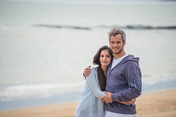 istock beautiful couple standing face to the ocean 475396538