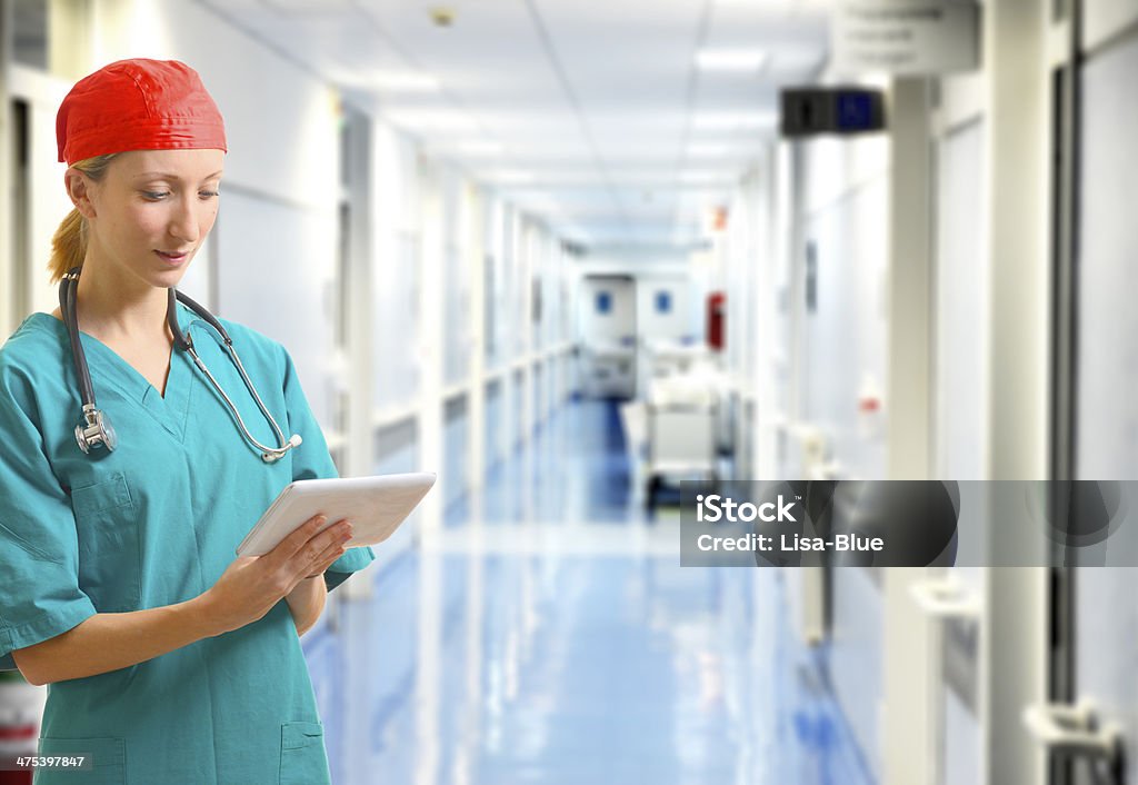 Female Doctor in Hospital Corridor Doctor with tablet in hospital corridor. Computer Stock Photo
