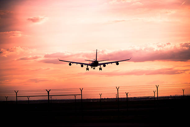 istock Airplane landing at sunset 475402337
