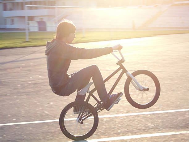istock Man riding a BMX bike on the back wheel 475402730