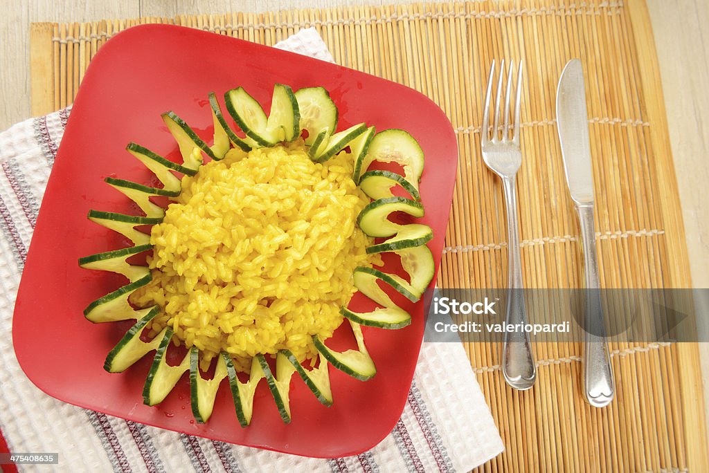 Plate decorated with saffron risotto Red plate decorated with saffron risotto Risotto Stock Photo