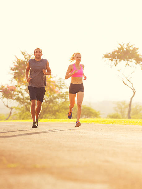 istock Couple running in the park at sunrise 475413551