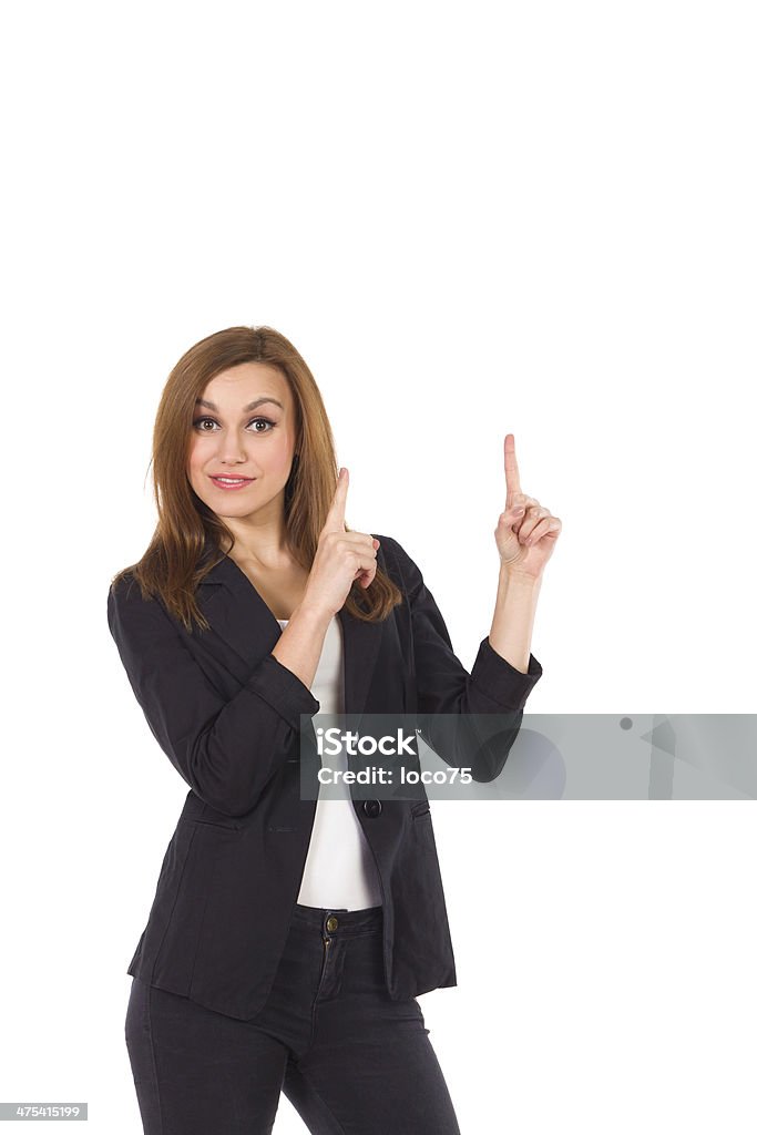 Business woman pointing at empty space. Business woman pointing at empty space. Three quarter length studio shot isolated on white. Arms Raised Stock Photo