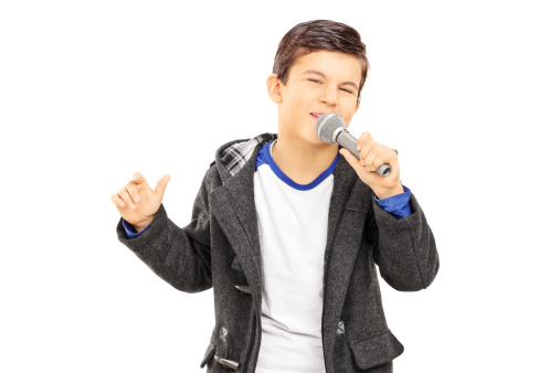 Boy singing on microphone isolated on white background
