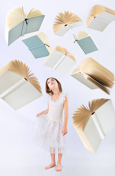 istock Flying books over little girl looking up 475416963