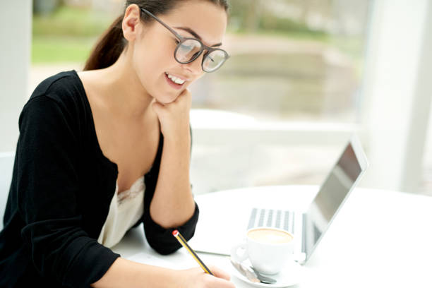 istock Woman smiling as she sits working at her desk 475417262