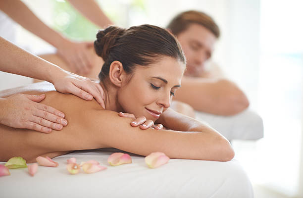 They deserve this pampering A husband and wife lying receiving massages at a spa couple retreatspa stock pictures, royalty-free photos & images