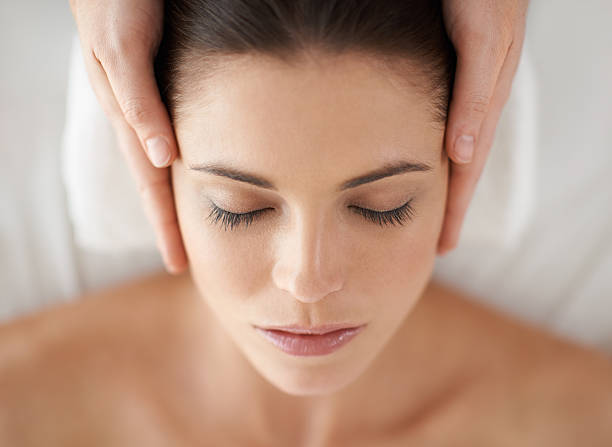 Pure bliss A young woman receiving a face massage facial massage stock pictures, royalty-free photos & images