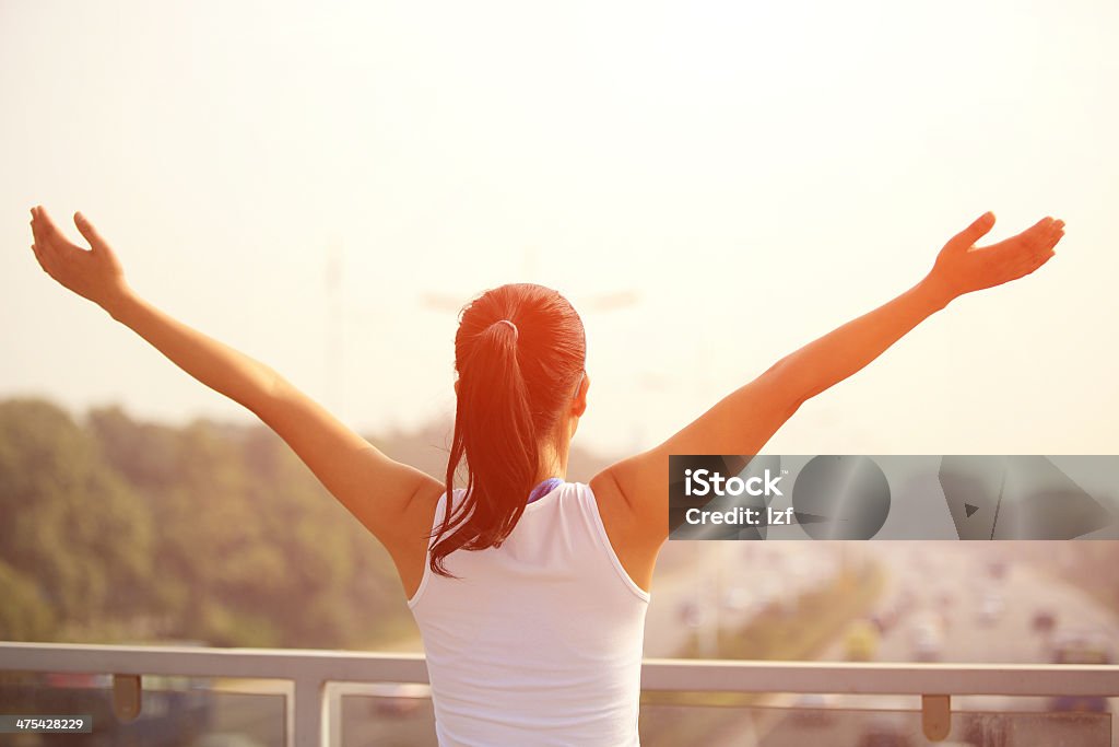 woman stand at the pedestrian overpass open arms sporty woman stand at the pedestrian overpass open arms to the rush driveway in modern city Adult Stock Photo