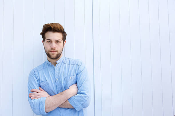 istock Serious young modern man standing with arms crossed 475429354