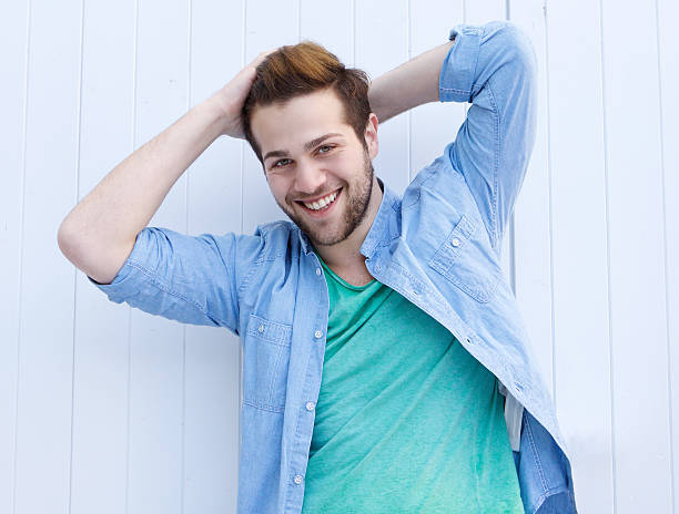 istock Cool fashionable guy smiling with hands in hair 475430090