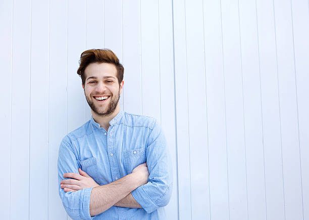 istock Attractive young man smiling with arms crossed 475430496
