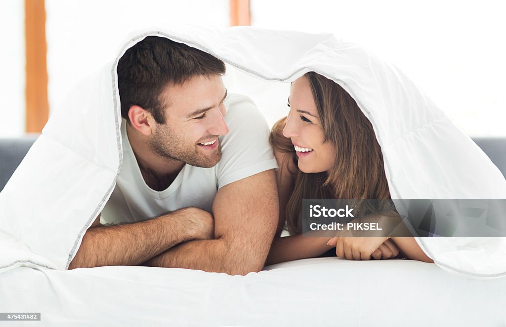 Couple relaxing on bed 2015 Stock Photo